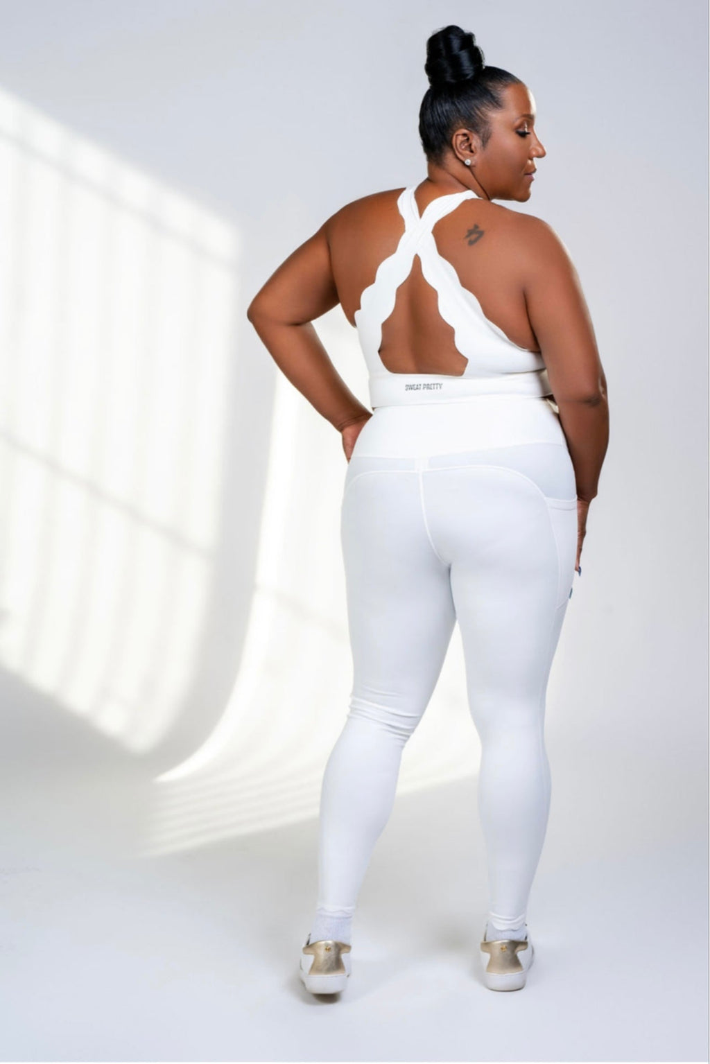 Person wearing a white outfit with cut-out design on a light background
