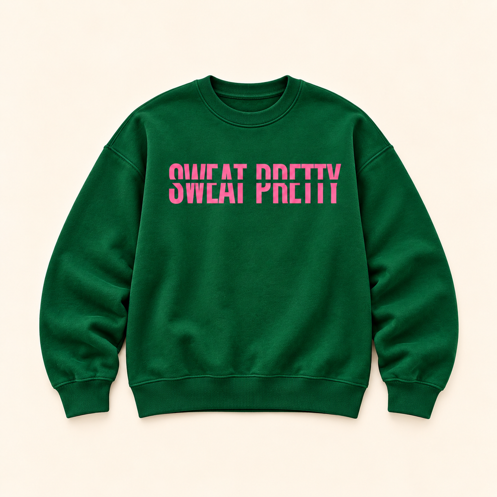 A dark green crewneck sweatshirt with the phrase 'SWEAT PRETTY' printed across the chest in a vibrant pink stencil font, displayed flat against a light beige background.