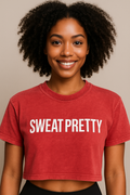 Person wearing a red 'SWEAT PRETTY' t-shirt against a neutral background