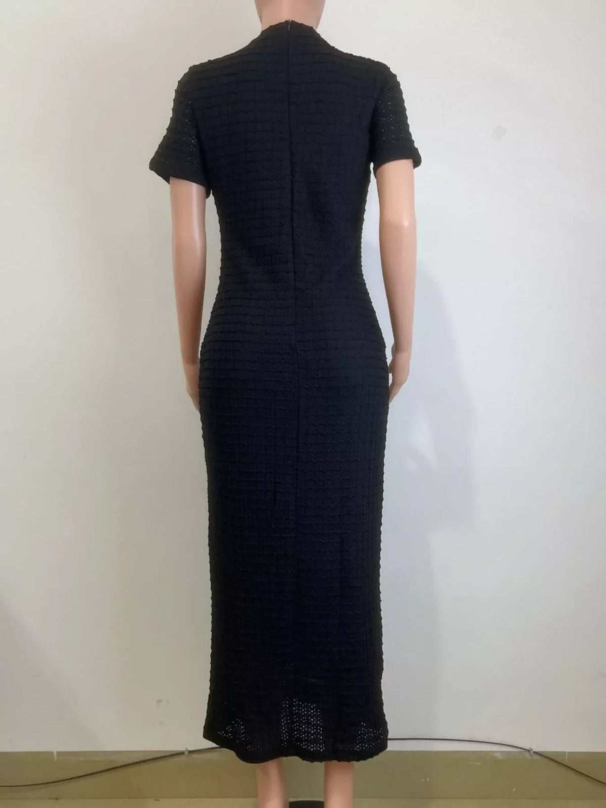 Black dress on a mannequin against a white background