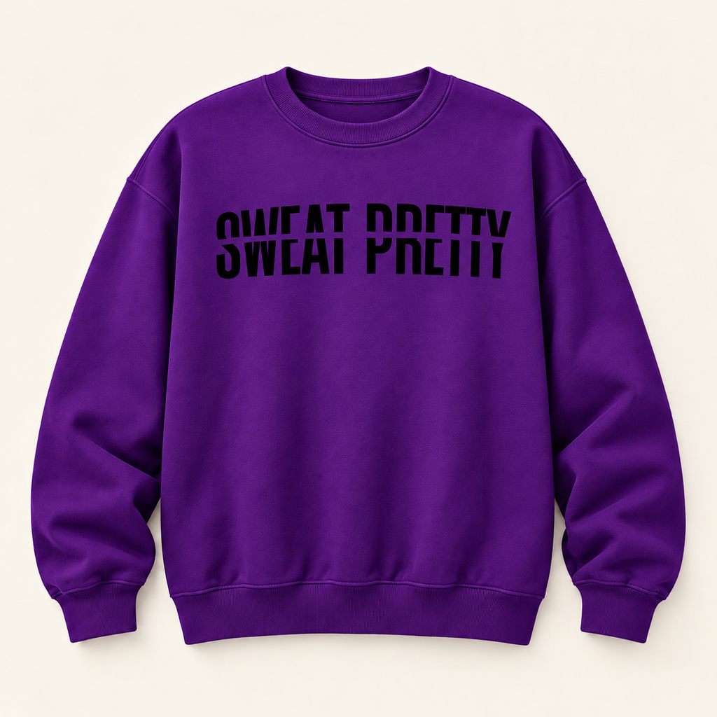 A purple crewneck sweatshirt with the phrase 'SWEAT PRETTY' printed in black across the chest, displayed flat against a light cream background.
