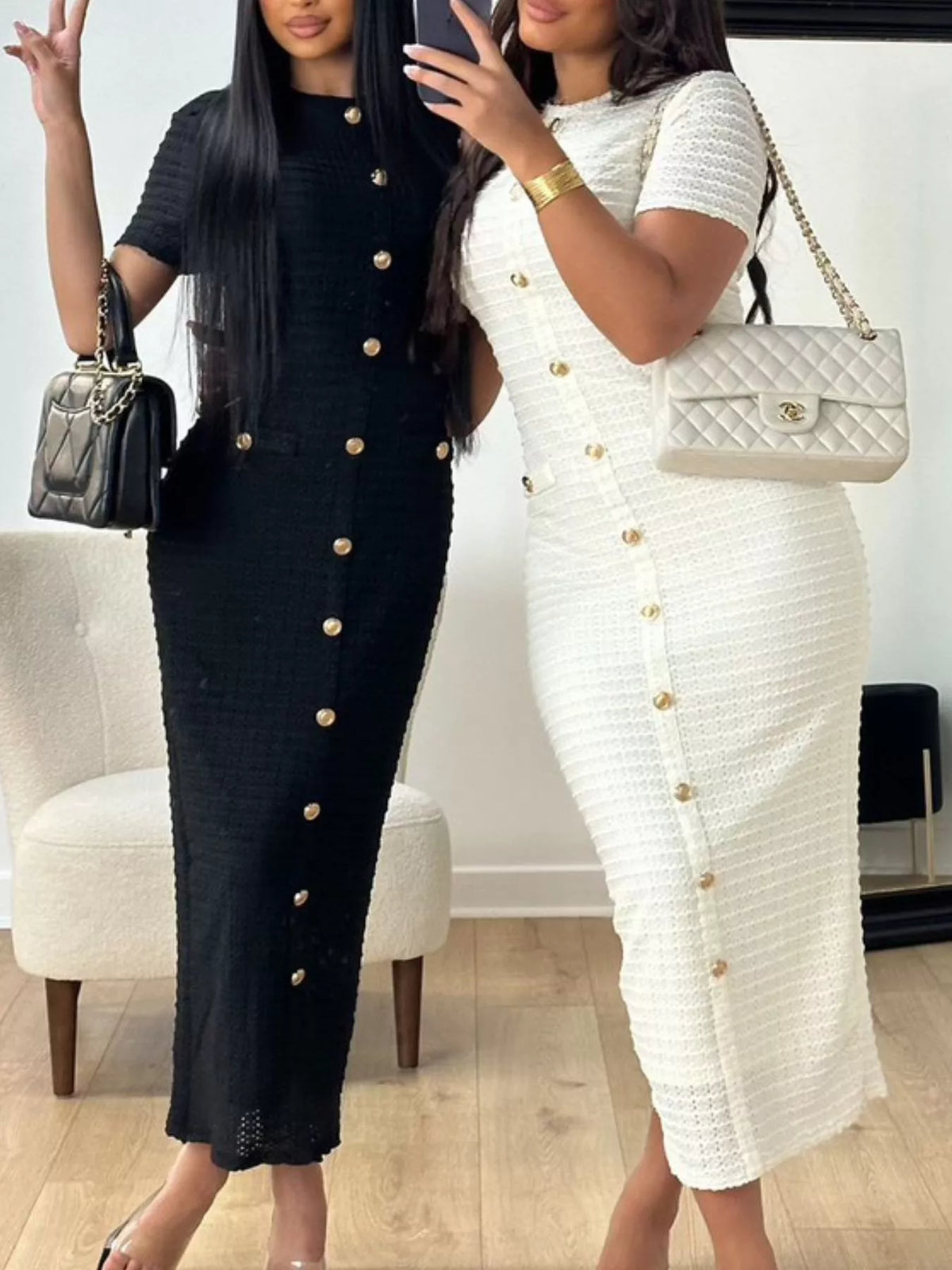 Two women wearing black and white button-up dresses with handbags.