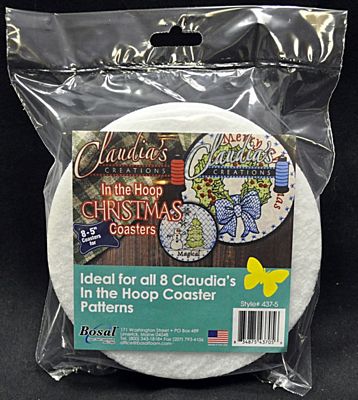 A packaged white circular coaster inside a clear plastic bag with a printed front label. The label reads 'In the Hoop Christmas Coasters' and shows branding for Claudia's Creations and Rosal.