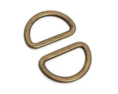 Two antique bronze metal D-rings with a textured finish, arranged diagonally on a plain white background.