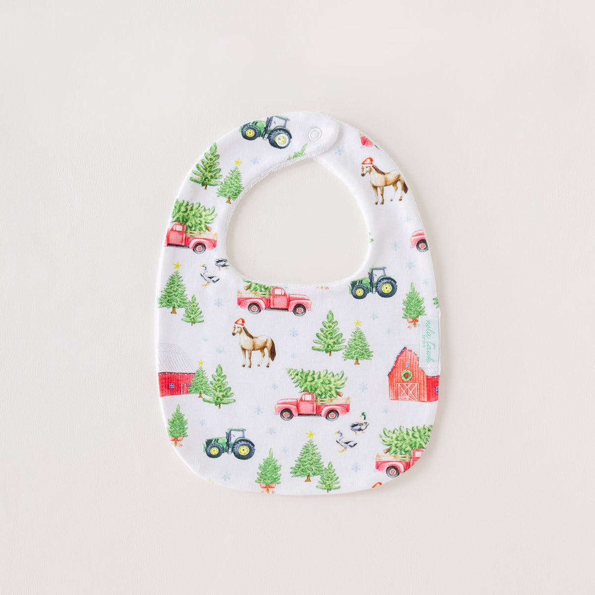 Baby bib with farm-themed pattern on a white background