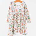 A long-sleeve white dress with a colorful cartoon animal and food print, hanging on a wooden hanger against a plain white background.