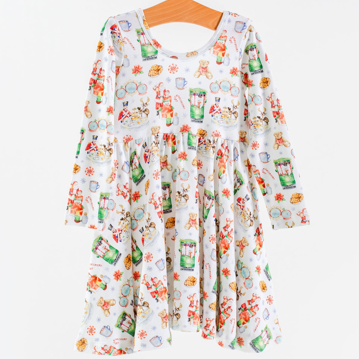 A long-sleeve white dress with a colorful cartoon animal and food print, hanging on a wooden hanger against a plain white background.