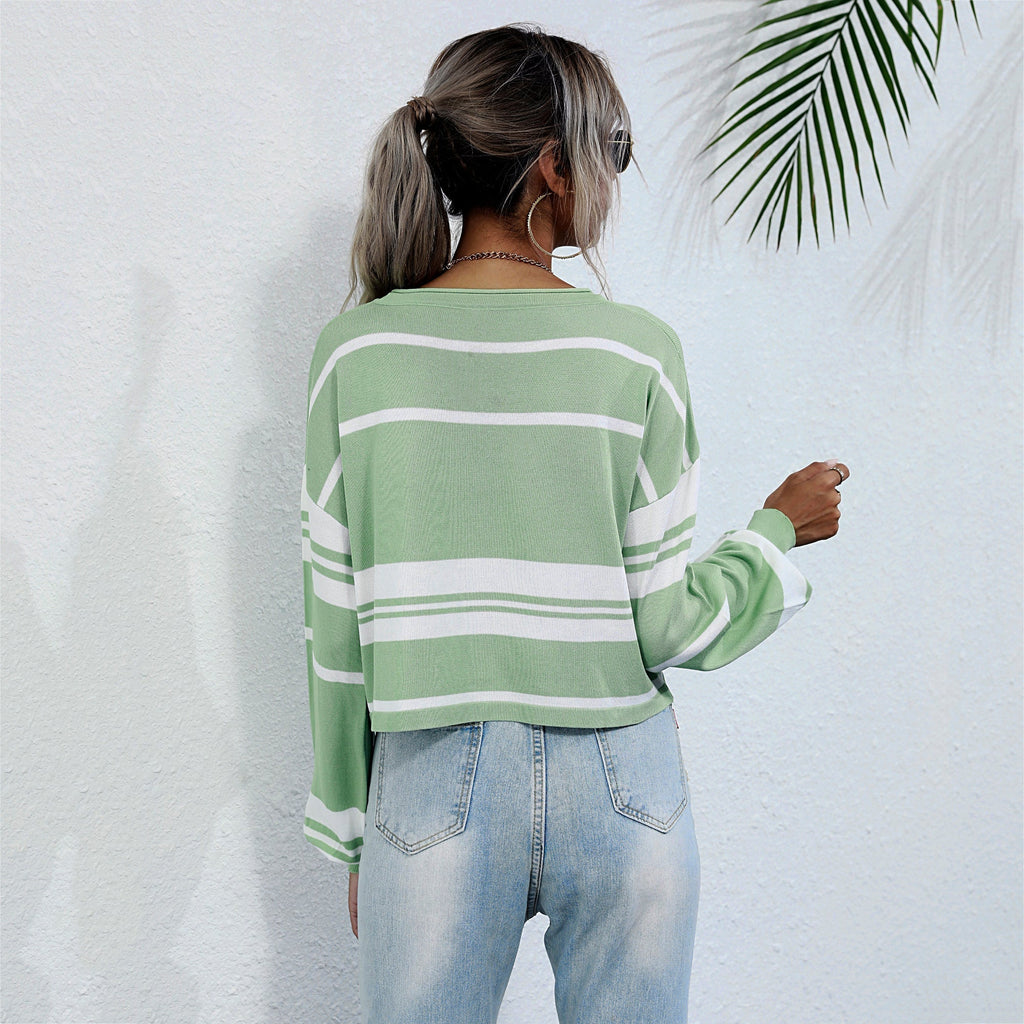 Person wearing a green and white striped sweater against a white background