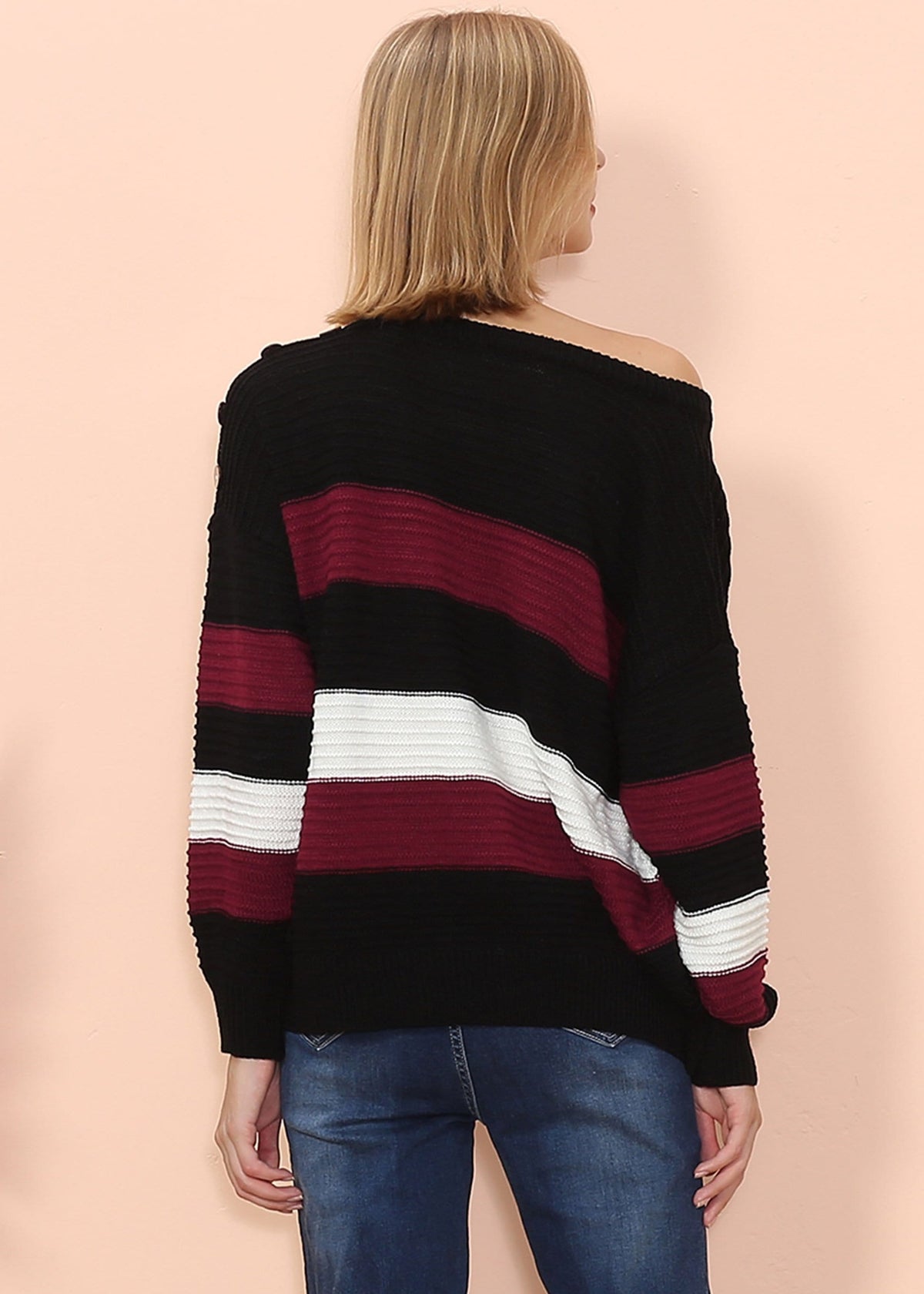 Woman wearing a black, red, and white striped sweater on a beige background