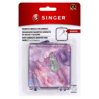 Singer brand magnetic needle and pin compact in blister packaging, featuring a pink and purple marbled design with a silver metal pin holder in the center.