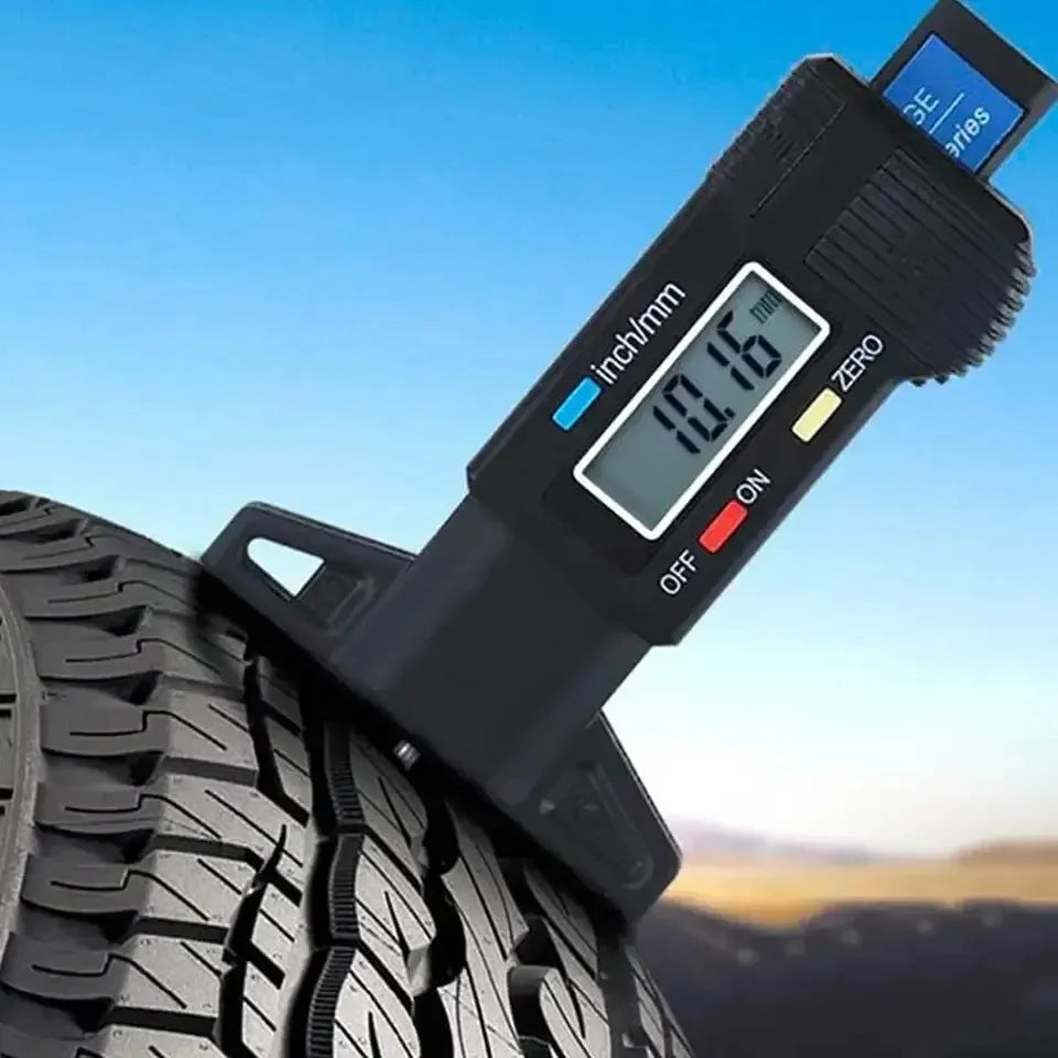 Digital tire pressure gauge on a tire with a blue sky background