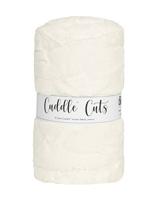 A rolled-up cream-colored plush fabric with a white paper band label that reads 'Cuddle Cuts'.