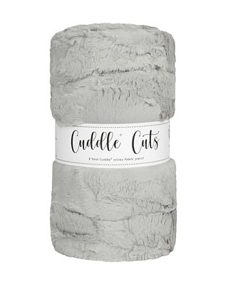 A folded plush faux fur fabric in a light gray color, wrapped with a white paper label that reads 'Cuddle Cats'.