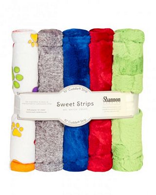 A set of six rolled plush fabric strips in assorted colors, wrapped together with a paper band labeled 'Sweet Strips' and 'Shannon'. The colors include white, gray, blue, red, and light green, with some blankets showing small printed paw prints.