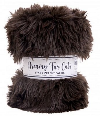 A roll of dark brown faux fur fabric with a white paper label that reads 'Dreamy Fur Cuts 1 Yard Precut Fabric' on a white background.