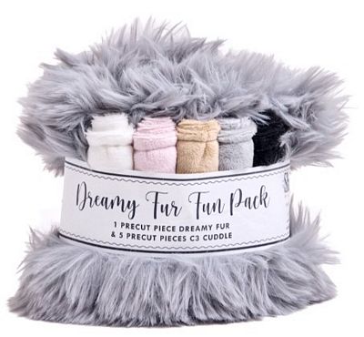 A packaged plush faux-fur craft bundle labeled 'Dreamy Fur Fun Pack,' showing gray fluffy trim around the edges and several folded fabric pieces inside, including white, pink, beige, gray, and black.