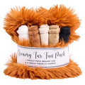 Dreamy Fur Fun Pack containing a large orange fluffy faux fur piece and five smaller rolled fabric pieces in white, tan, cream, and black, wrapped in a white paper band with black text.