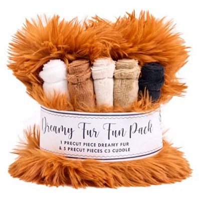 Dreamy Fur Fun Pack containing a large orange fluffy faux fur piece and five smaller rolled fabric pieces in white, tan, cream, and black, wrapped in a white paper band with black text.