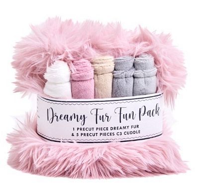 A pink fluffy faux-fur wrapped gift set labeled 'Dreamy Fur Fun Pack,' containing five rolled precut pieces in white, pink, beige, gray, and blue-gray, on a white background.