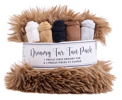 Dreamy Fur Fun Pack containing a fluffy brown faux fur blanket and five pre-cut cozy pieces in white, tan, charcoal, brown, and light gray, wrapped in a white paper band.