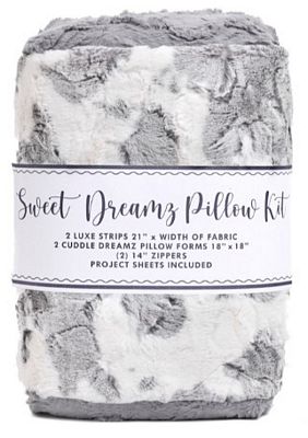 A folded plush throw blanket in a gray and white marbled pattern, wrapped with a paper label that reads 'Sweet Dreamz Pillow Kit' and lists included fabric strips, pillow forms, and zipper sheets.