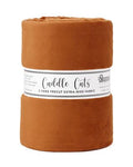 A roll of warm rust-brown fleece fabric with a white paper label reading 'Cuddle Cats' and 'Shannon Fabrics' on a plain white background.