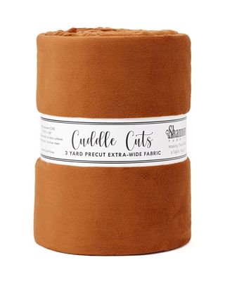 A roll of warm rust-brown fleece fabric with a white paper label reading 'Cuddle Cats' and 'Shannon Fabrics' on a plain white background.