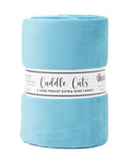 A light blue folded fleece blanket with a white paper label wrapped around it, photographed on a plain white background.