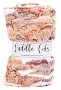 A roll of Cuddle Cuts cozy knit fabric with a white paper label, showing a marbled pattern of brown, beige, and cream yarn strands.