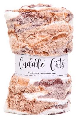 A roll of Cuddle Cuts cozy knit fabric with a white paper label, showing a marbled pattern of brown, beige, and cream yarn strands.