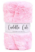 A folded bundle of fluffy pink faux fur or sherpa fabric by Cuddle Cuts, wrapped in a white paper band with black script text.