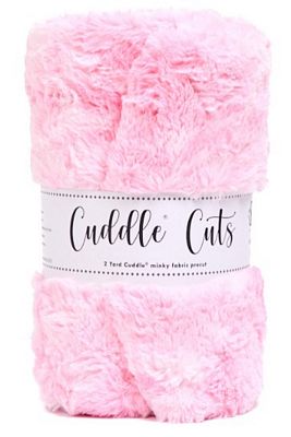 A folded bundle of fluffy pink faux fur or sherpa fabric by Cuddle Cuts, wrapped in a white paper band with black script text.