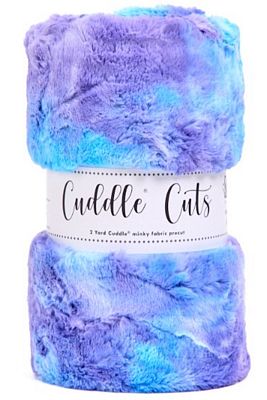 A roll of fuzzy plush fabric wrapped in a white paper band labeled 'Cuddle Cuts'. The yarn has a marbled pattern of purple, blue, and light teal.