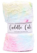 A folded plush faux-fur blanket with a pastel rainbow tie-dye pattern, wrapped in a white paper band labeled 'Cuddle Cuts'.