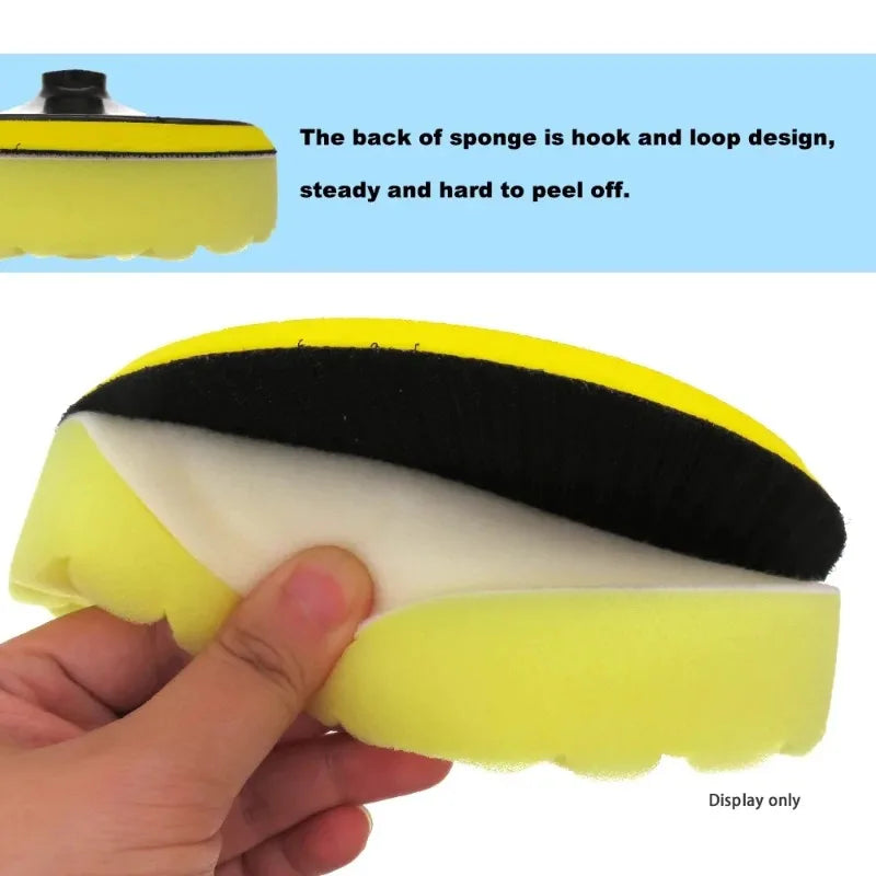 Yellow sponge with hook and loop design held by a hand, against a white background.