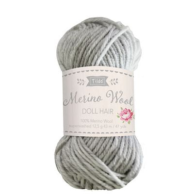 Ball of gray yarn with a label on a white background