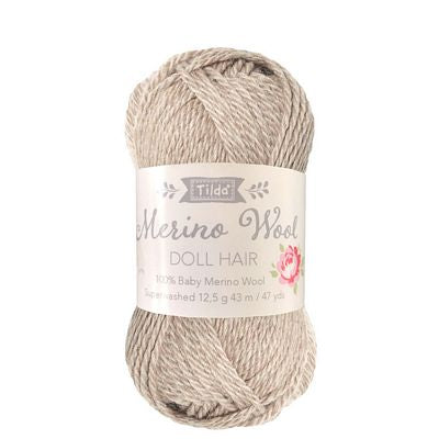 Ball of beige yarn with a label on a white background