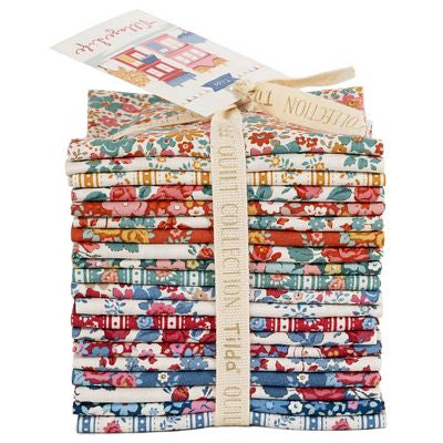 A stack of folded patterned fabric pieces tied with a cream ribbon and paper tag, shown on a plain white background. The fabrics feature floral, striped, and geometric designs in red, blue, green, orange, and white.