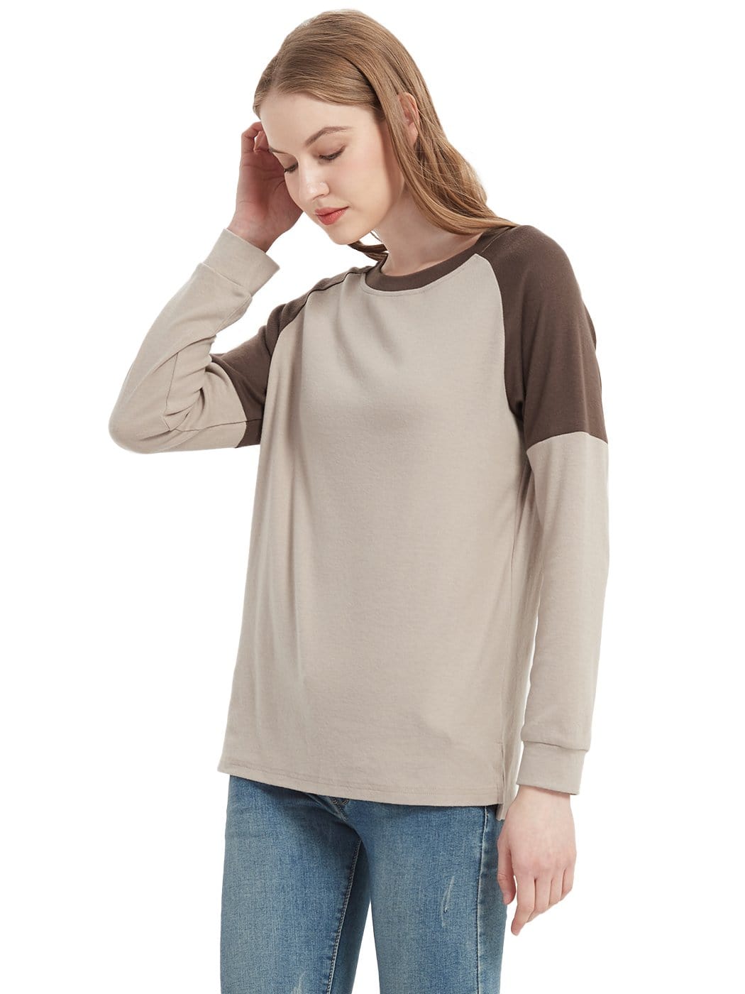 Woman wearing a beige and brown long-sleeve shirt with blue jeans on a white background