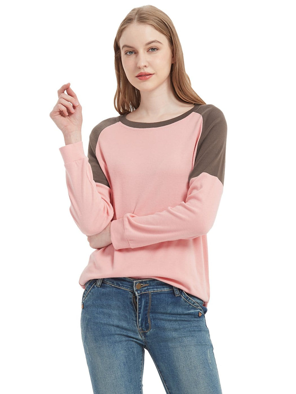 Woman wearing a pink and brown long-sleeve top with blue jeans on a white background