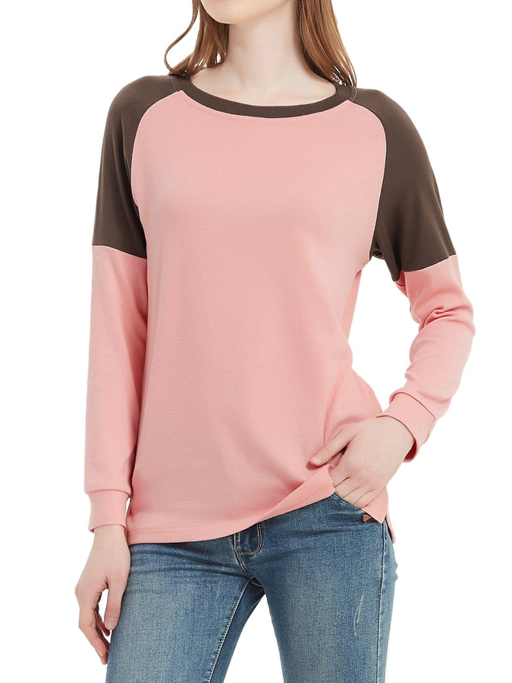 Person wearing a pink and brown long-sleeve shirt with blue jeans on a white background