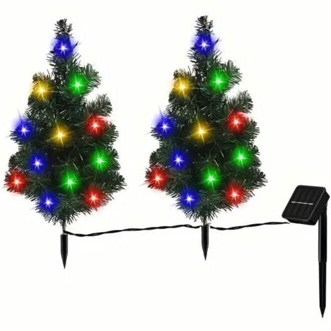 Two small artificial trees with colorful lights and a solar panel on a white background